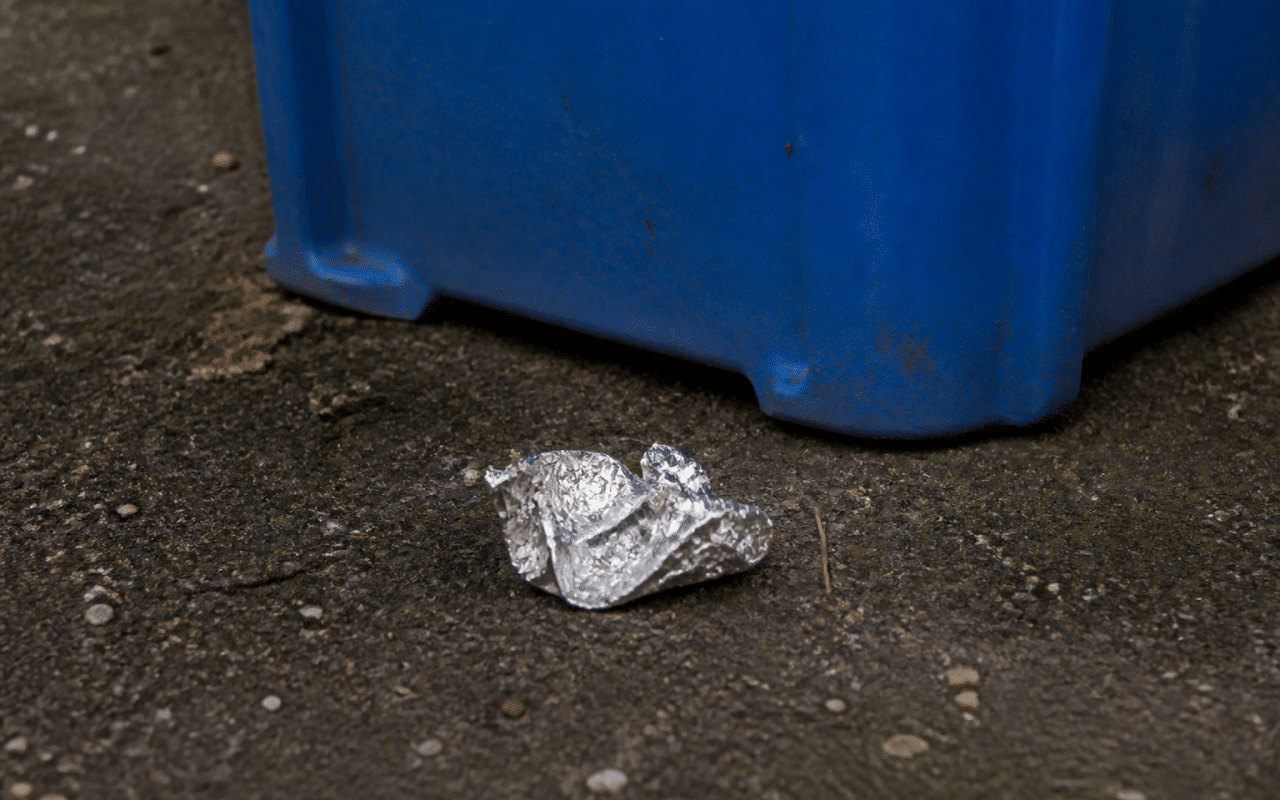 Feuille aluminium froissee posee pres bac recyclage bleu