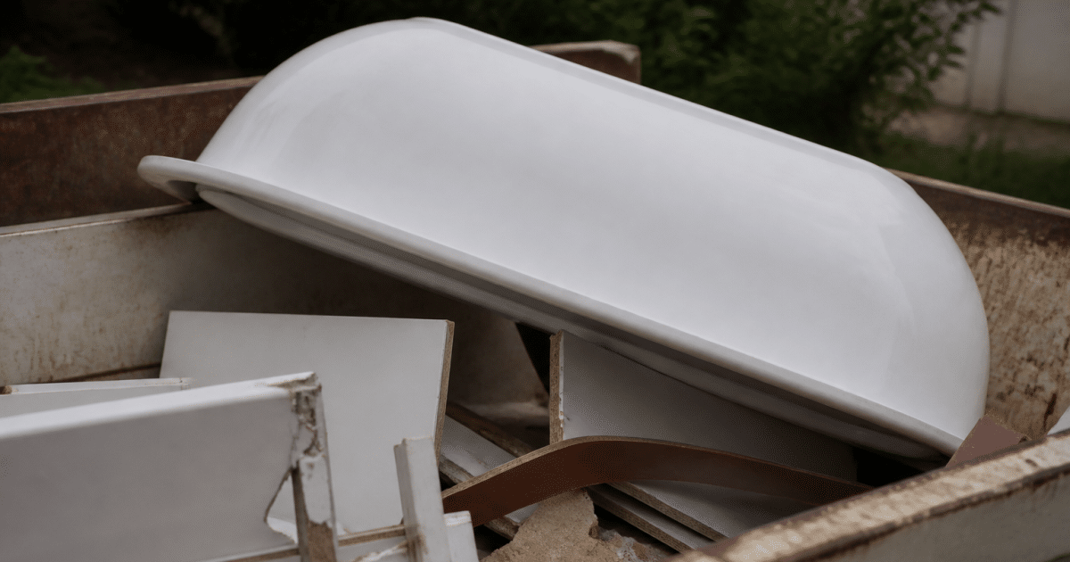 Baignoire blanche renversee dans benne recyclage municipale