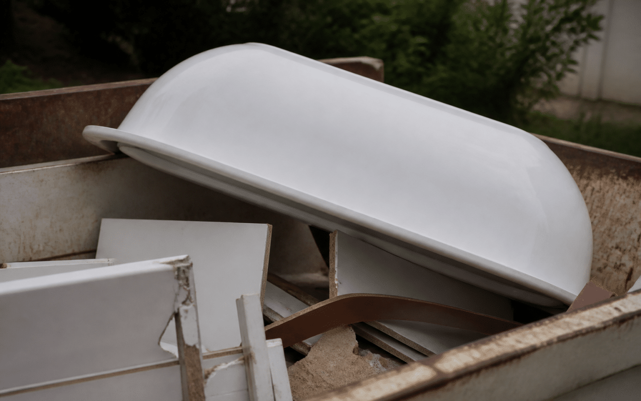 Baignoire blanche renversee dans benne recyclage municipale
