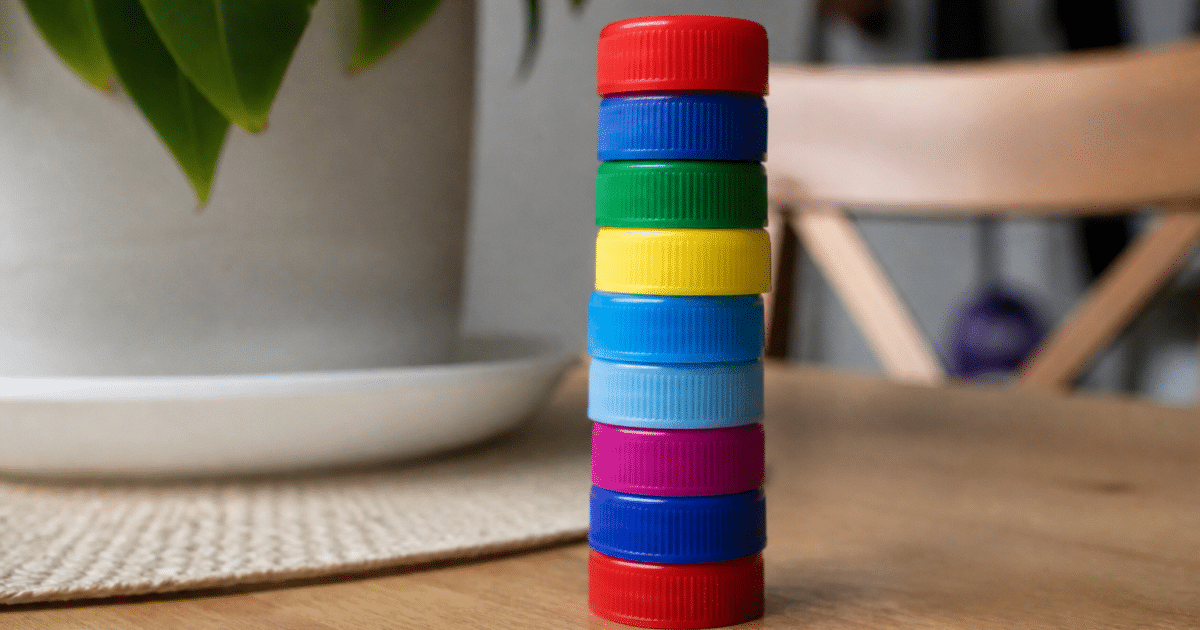 Pile de bouchons plastique colores empiles verticalement sur table