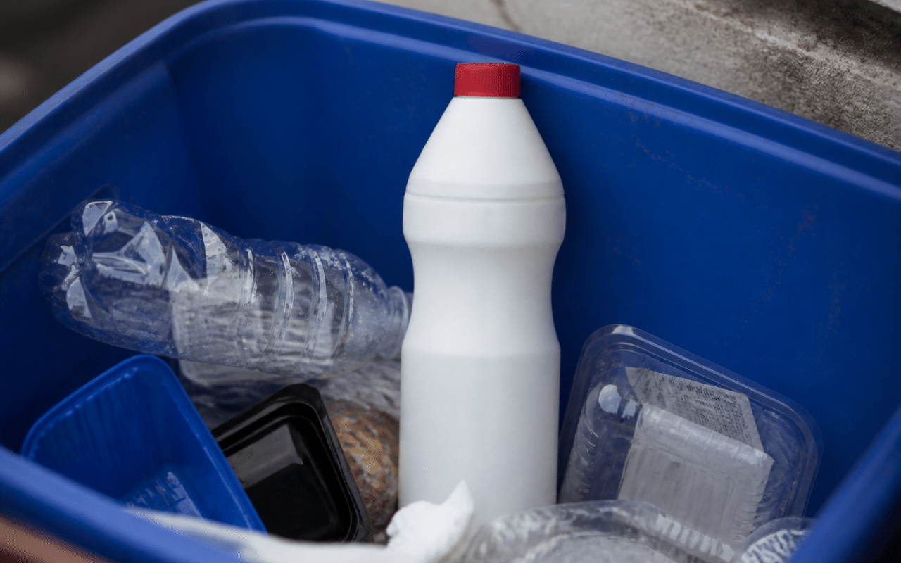 Bouteille plastique insecticide posee verticalement dans bac recyclage