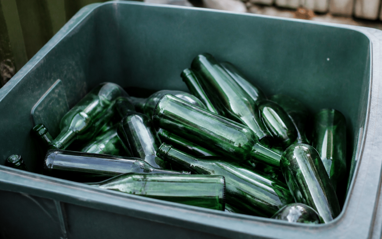 Bouteilles vertes empilees dans bac de tri selectif