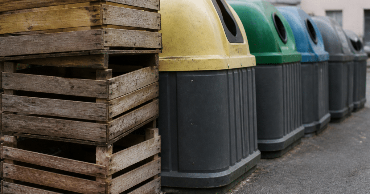 Caisses bois empilees pres de conteneurs tri selectif colorés