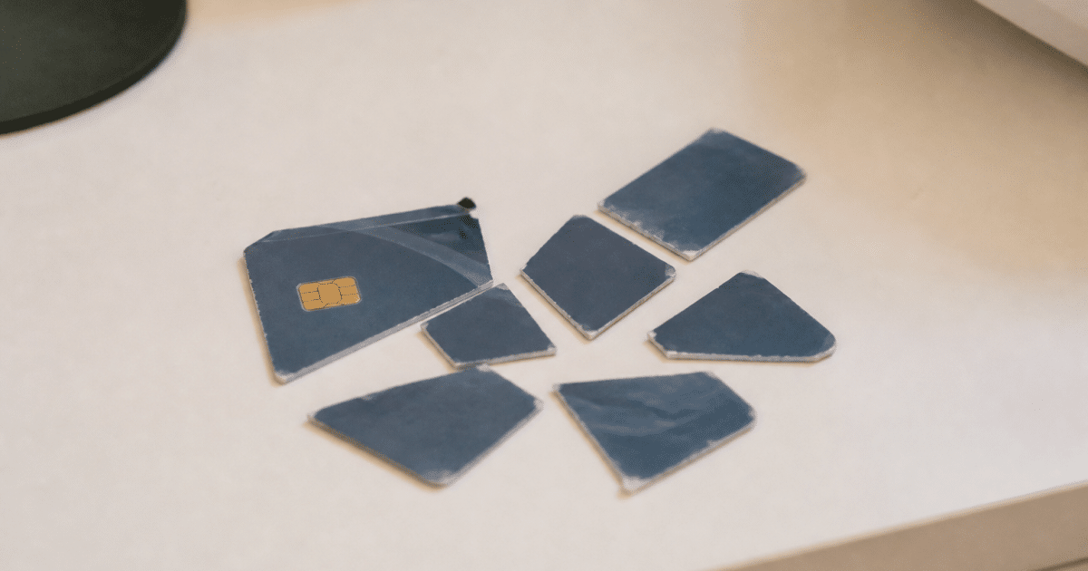 Carte bancaire usagee coupee en morceaux sur table blanche