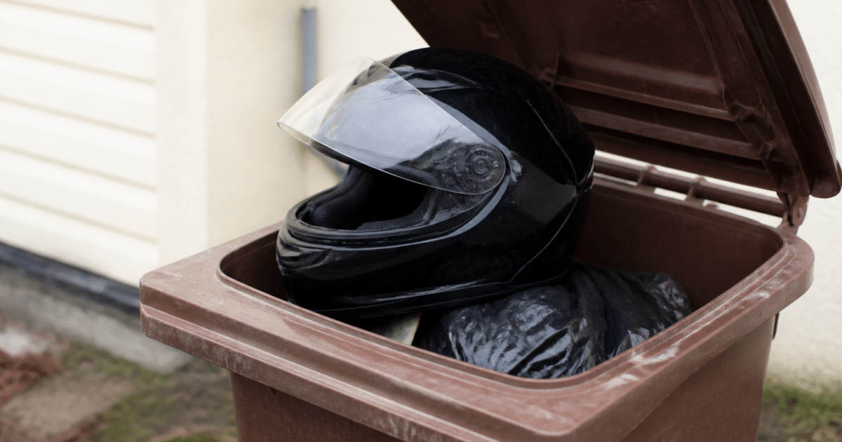 Casque de motocyclette pose sur bac recyclage ouvert