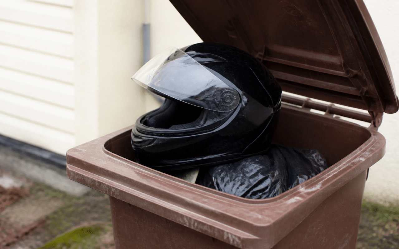 Casque de motocyclette pose sur bac recyclage ouvert