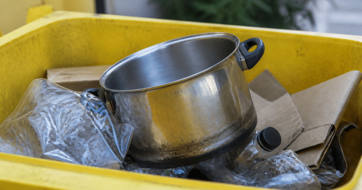 Casserole metallique posee dans bac recyclage jaune