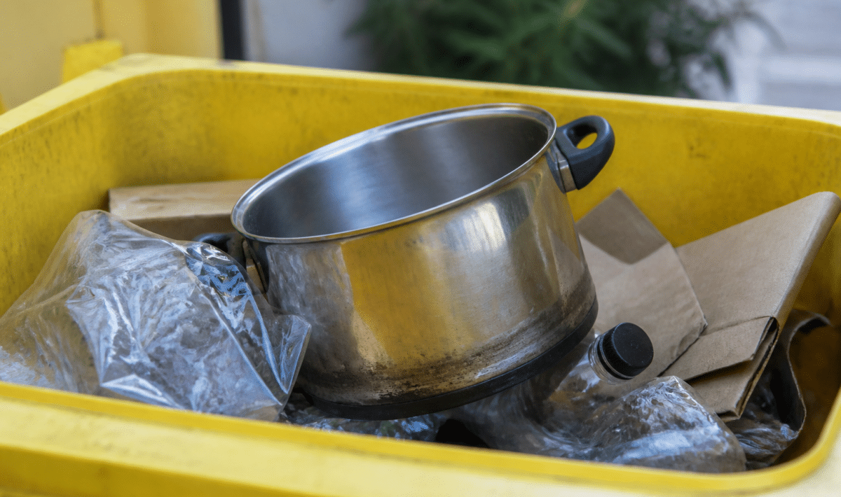 Casserole metallique posee dans bac recyclage jaune