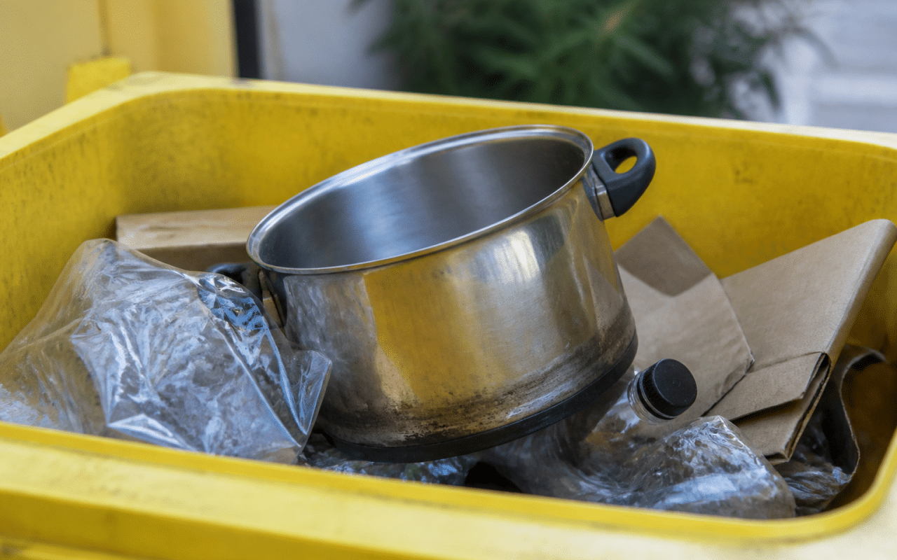 Casserole metallique posee dans bac recyclage jaune
