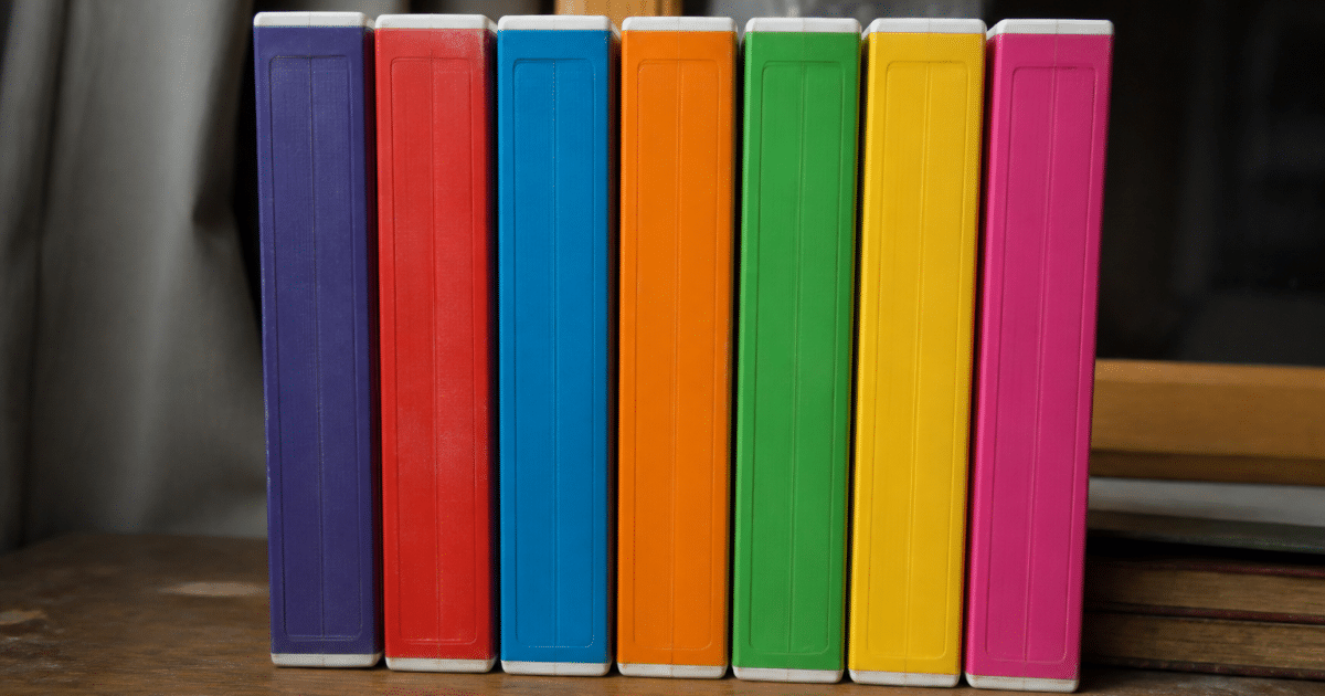 Pile de cassettes VHS colorees posees verticalement sur une surface plate