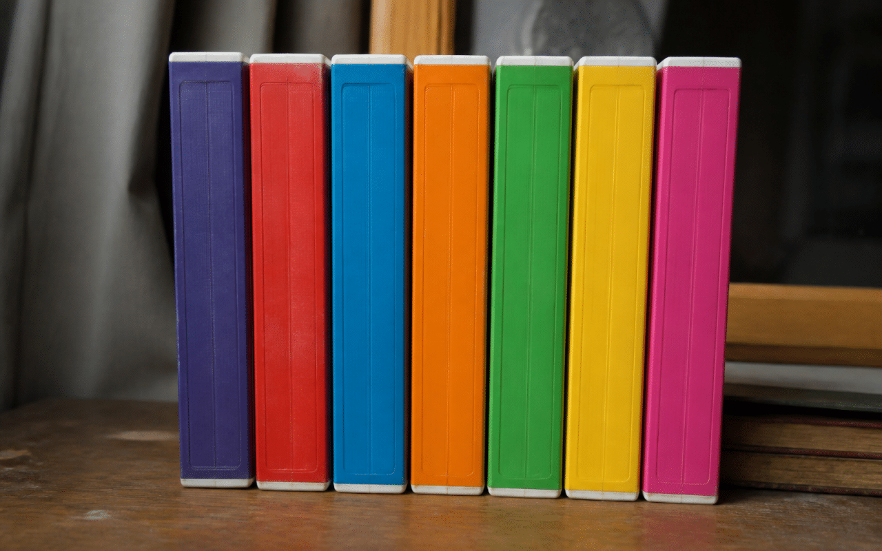 Pile de cassettes VHS colorees posees verticalement sur une surface plate