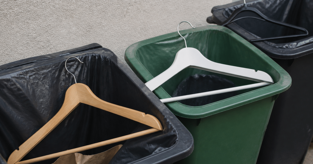 Trois cintres de matieres differentes poses dans poubelles de tri selectif