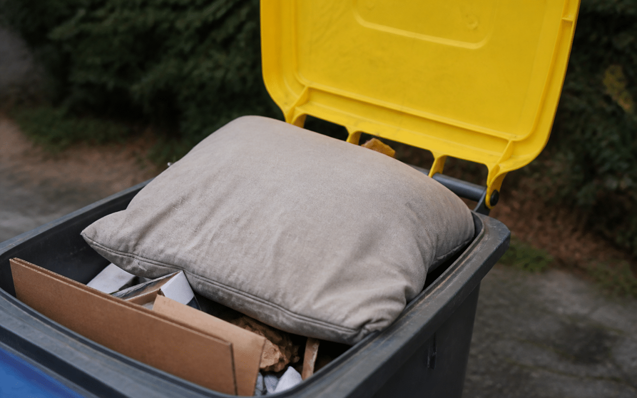 Coussin usé posé dans bac recyclage ouvert