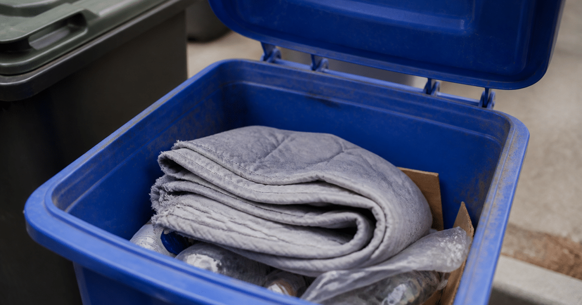 Couverture pliee posee dans un bac de recyclage ouvert