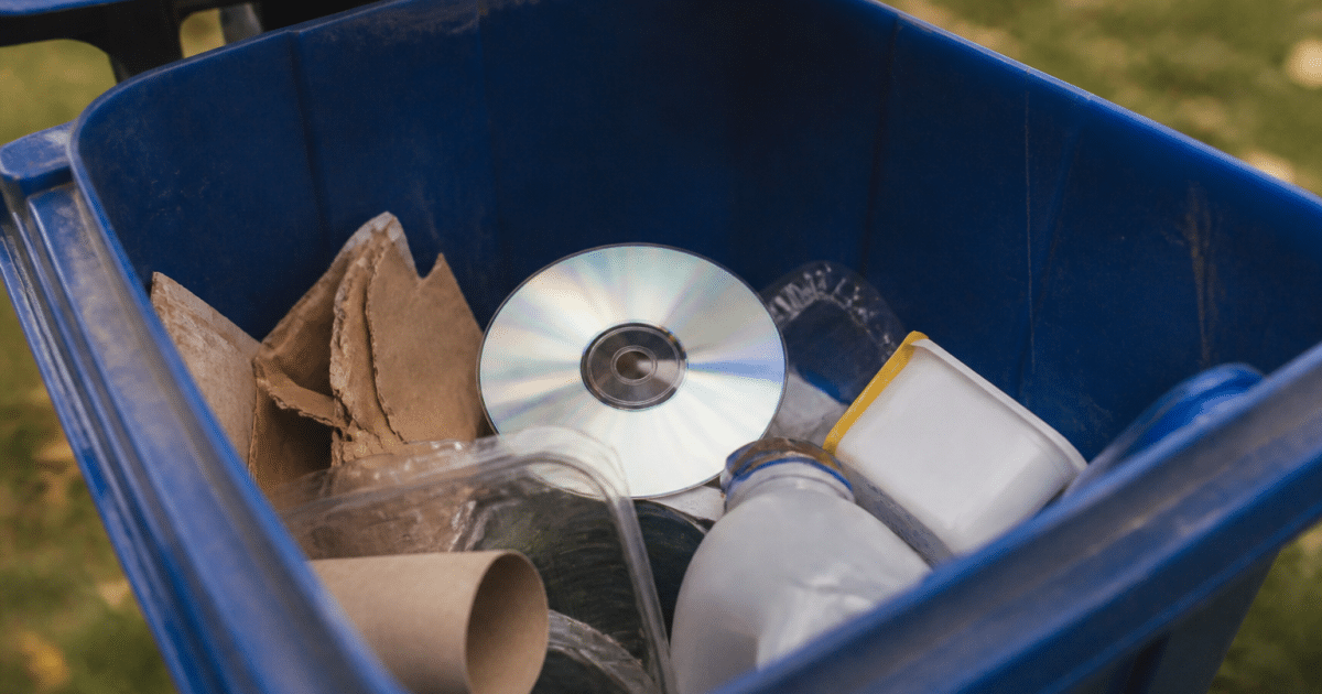 Disque DVD pose dans bac recyclage bleu
