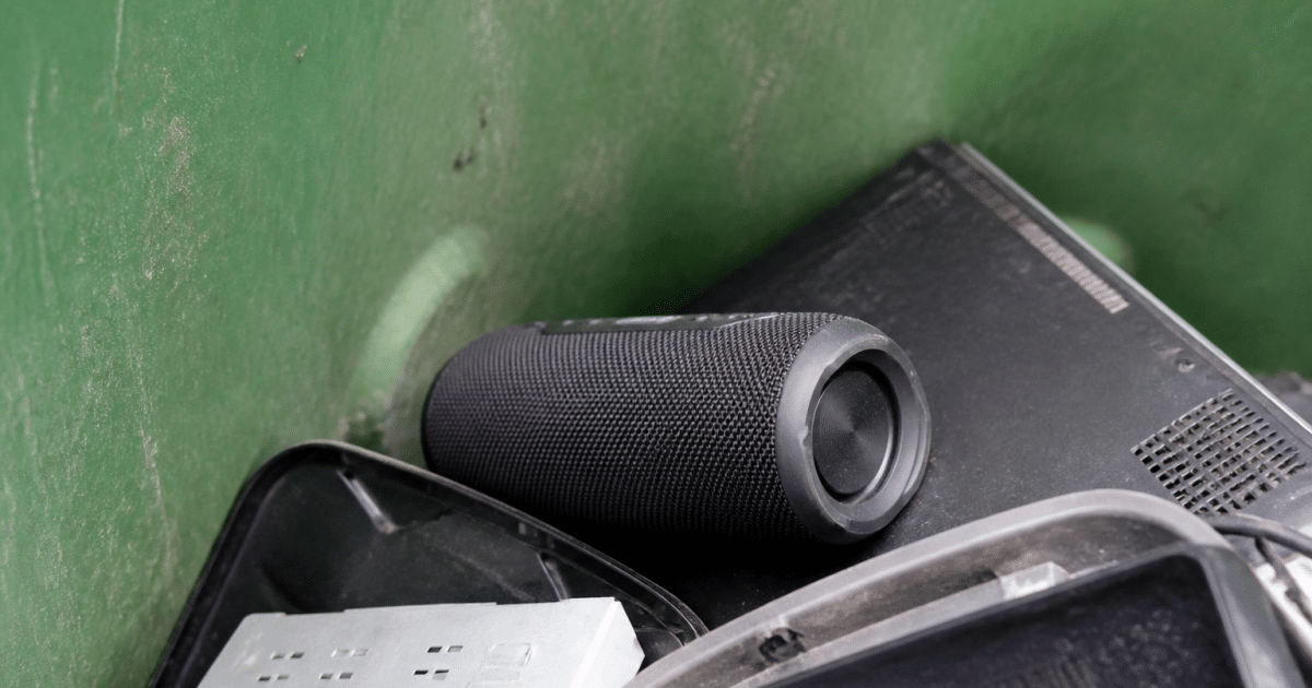 Enceinte bluetooth posee dans bac recyclage avec autres appareils electroniques