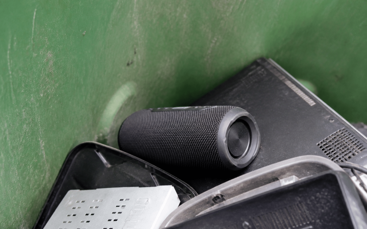 Enceinte bluetooth posee dans bac recyclage avec autres appareils electroniques