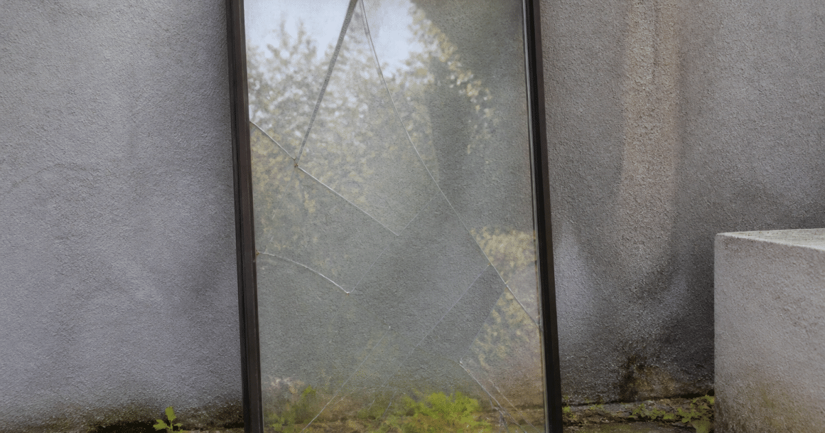 Fenetre cassee posee verticalement contre mur gris