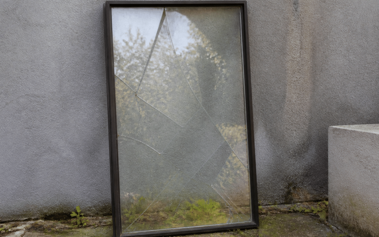 Fenetre cassee posee verticalement contre mur gris