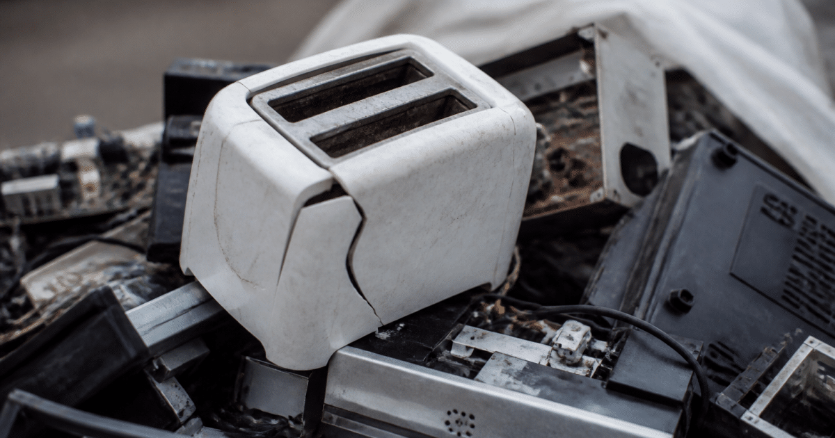 Grille-pain brisé posé sur tas de déchets électroniques