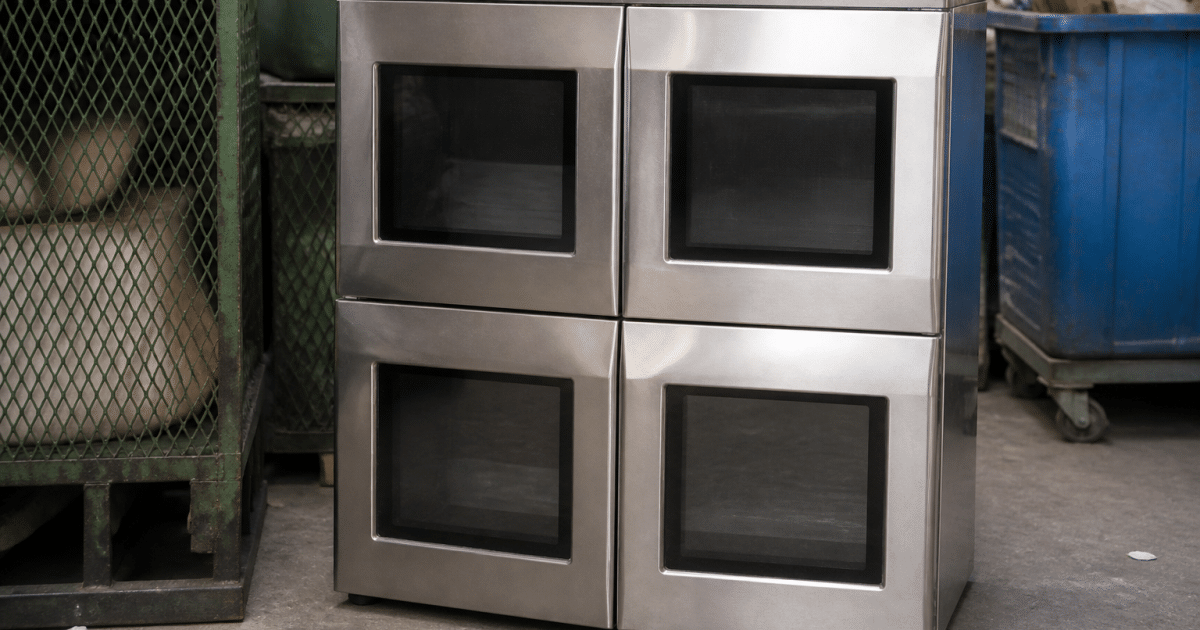 Four-door microwave oven positioned upright on recycling center floor
