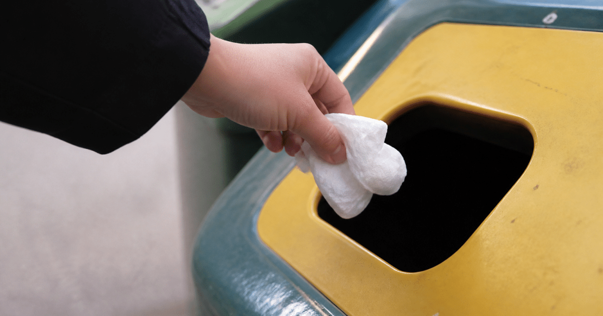 Main deposant mouchoir usage dans bac recyclage selectif