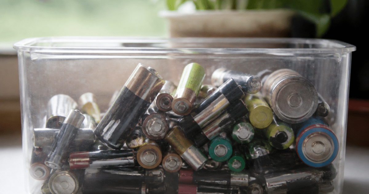 Pile usagees empilees dans un bac de collecte transparent