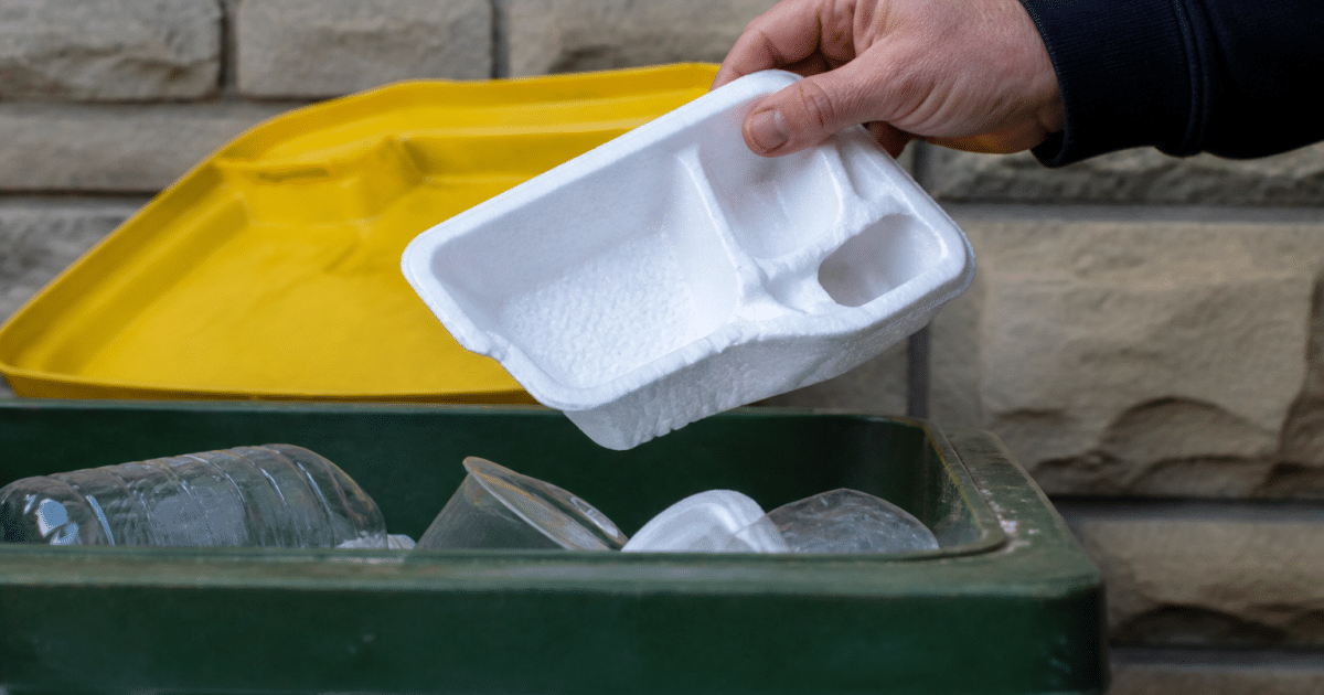 Mains tenant emballage polystyrene blanc au-dessus bac recyclage