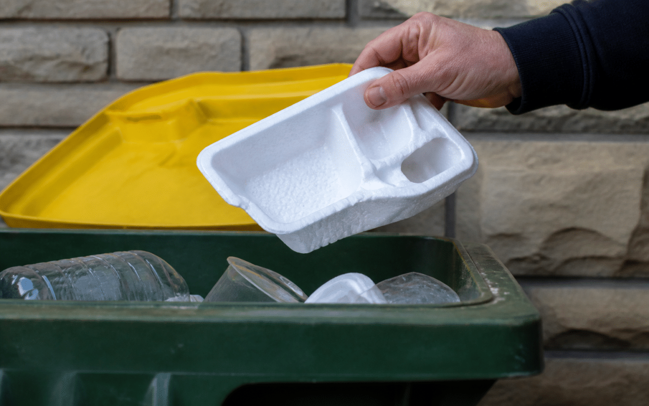 Mains tenant emballage polystyrene blanc au-dessus bac recyclage