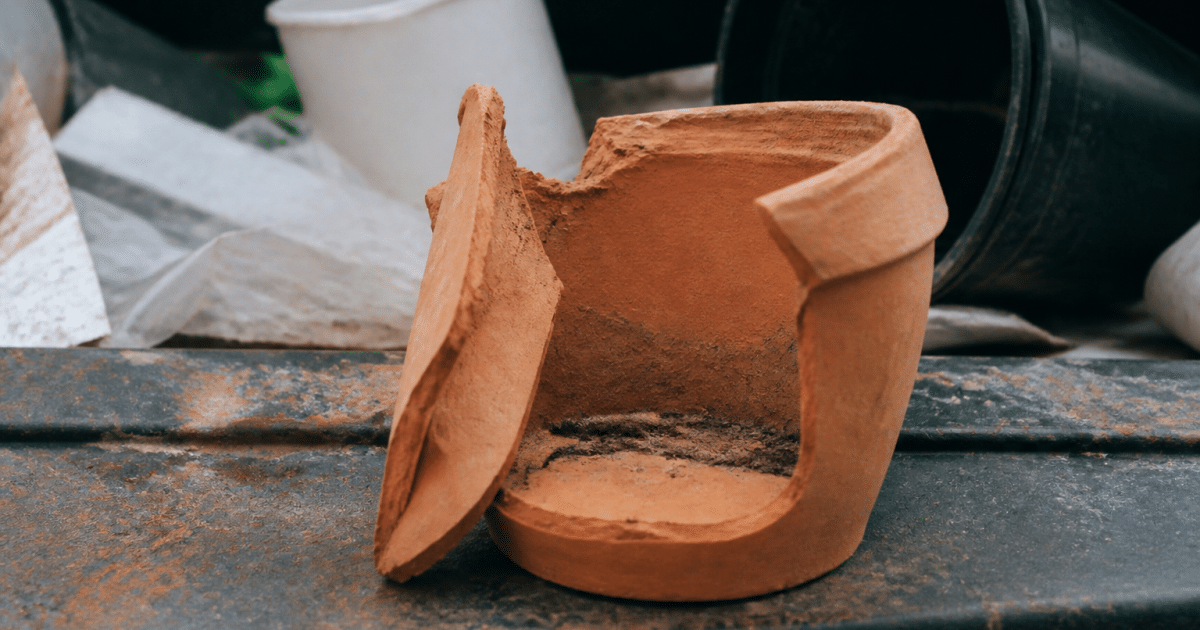 Pot en terre cuite brisé posé sur surface de recyclage