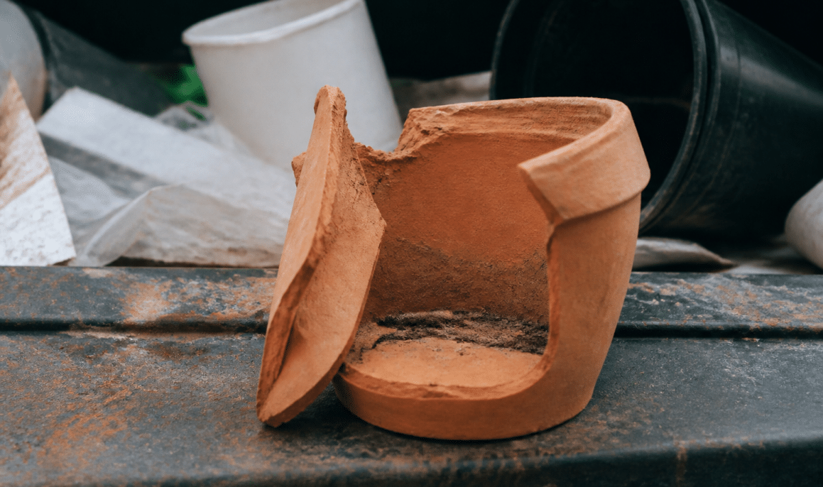 Pot en terre cuite brisé posé sur surface de recyclage