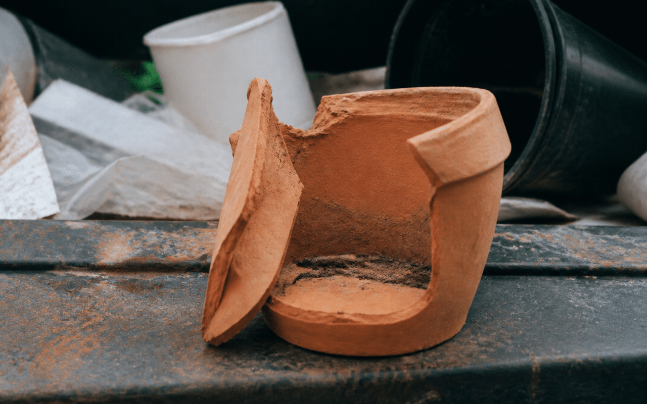 Pot en terre cuite brisé posé sur surface de recyclage