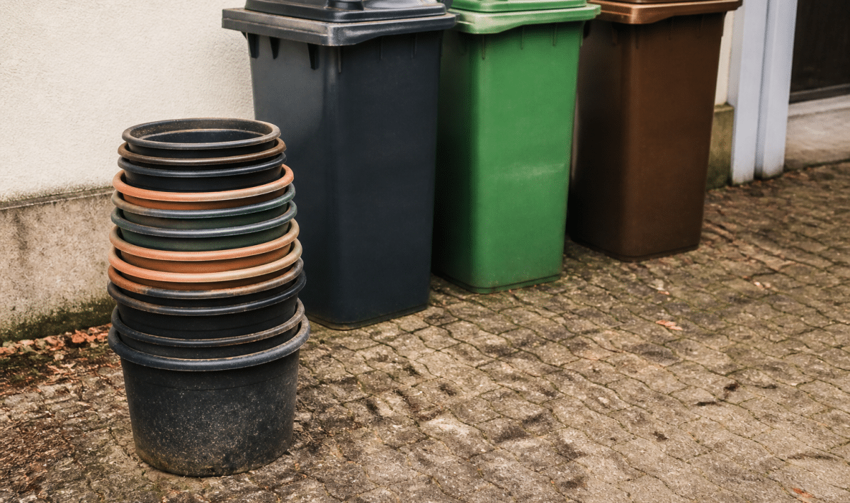 Pots plastique empiles pres de trois bacs de tri selectif