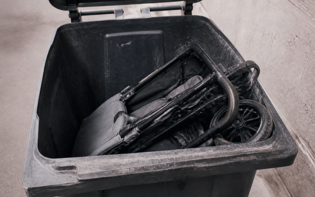 Poussette pliee posee dans bac recyclage municipal