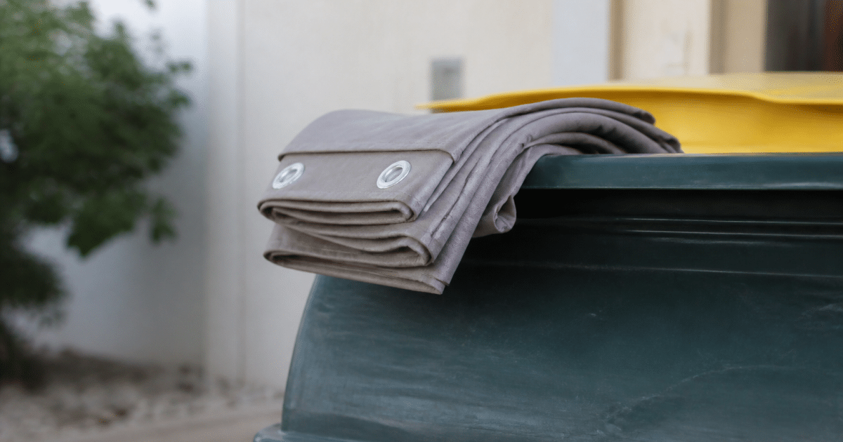 Rideau plié posé sur bord conteneur recyclage