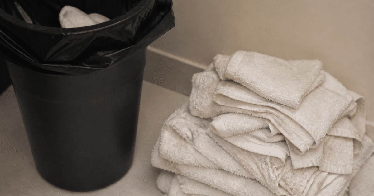 Serviettes de toilette usagees empilees pres d'une poubelle ouverte