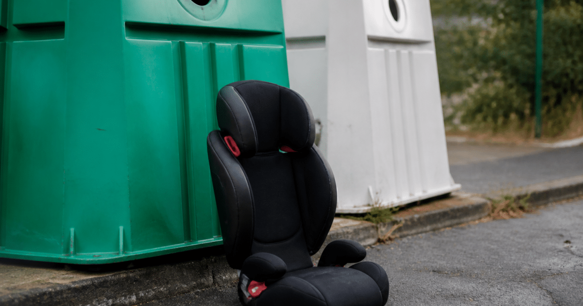 Siege auto enfant pose verticalement pres benne recyclage