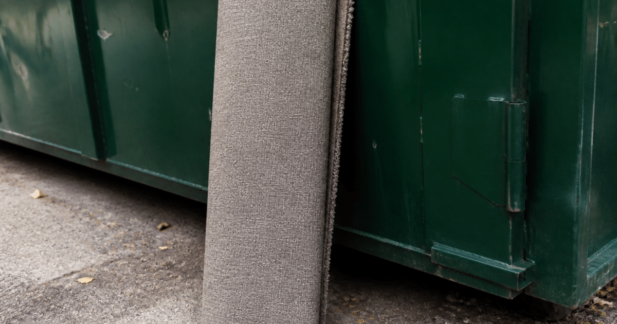 Tapis roulé posé verticalement contre benne de recyclage extérieure