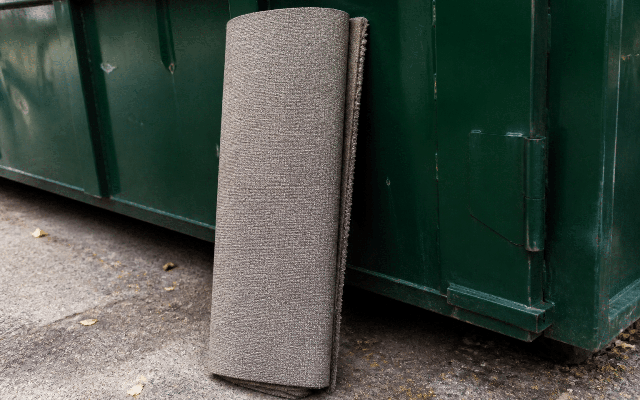 Tapis roulé posé verticalement contre benne de recyclage extérieure