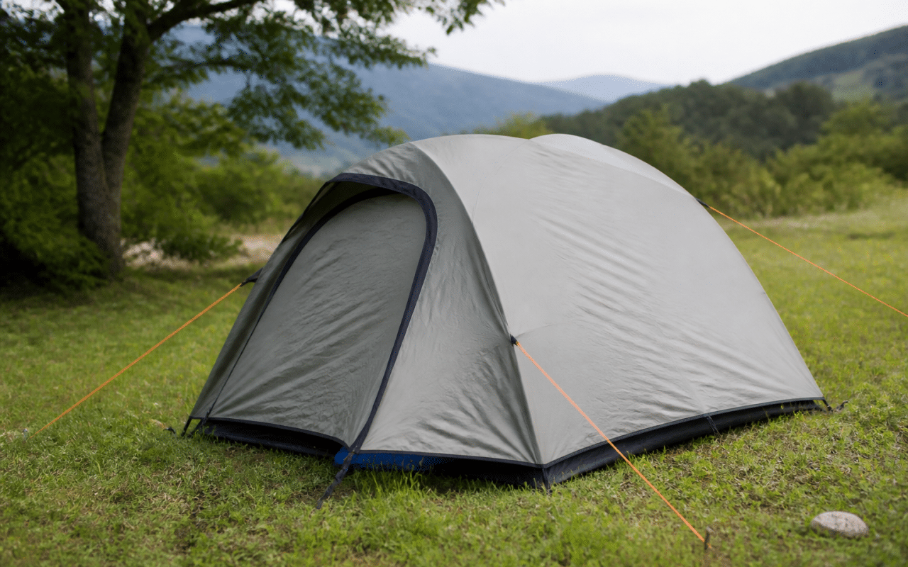 Tente dressée sur terrain herbeux avec piquets enfonces