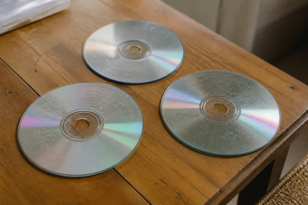 Disques CD rayes poses sur table en bois